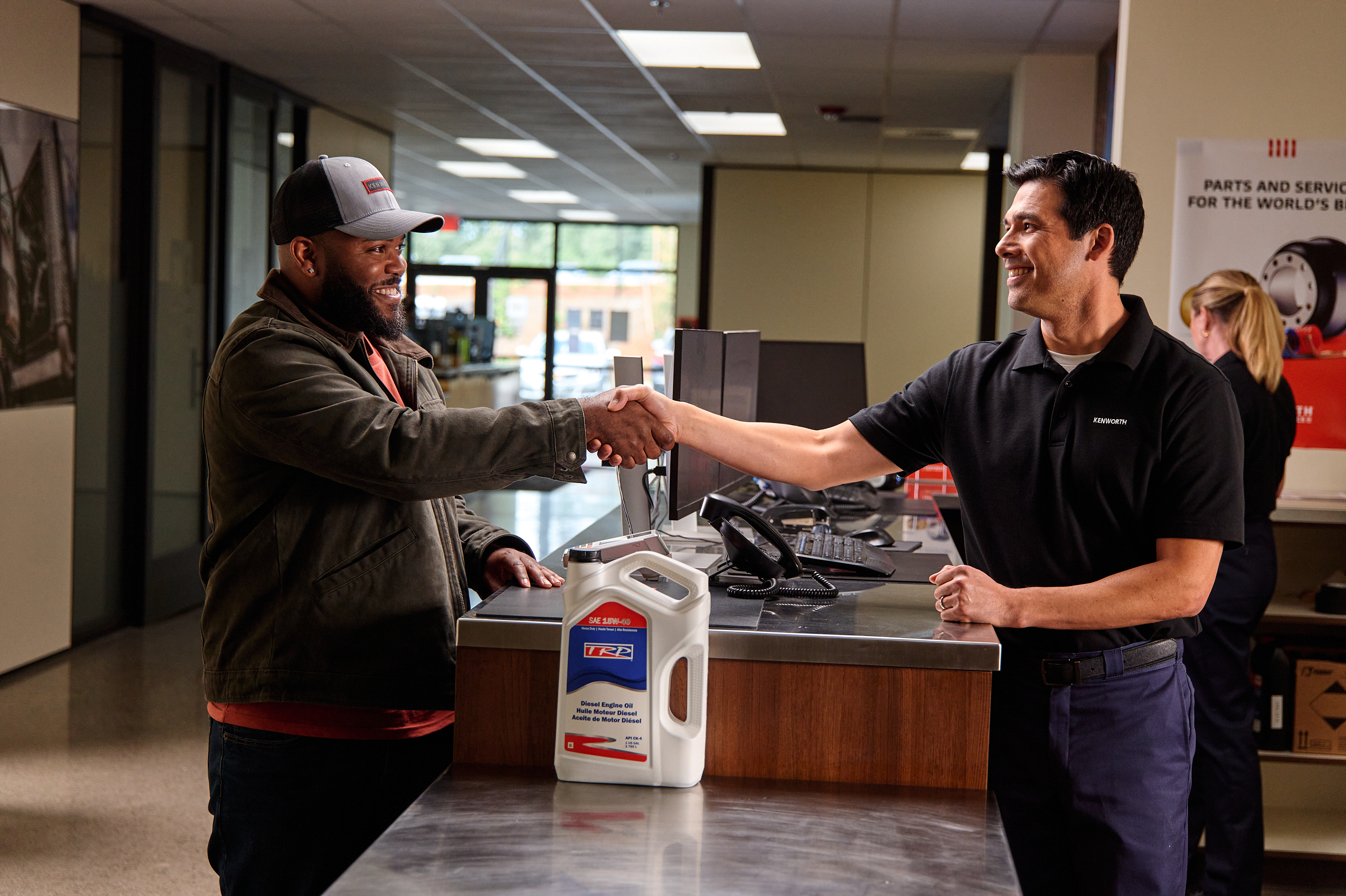 A Kenworth clerk explains a part to a customer in a dealership